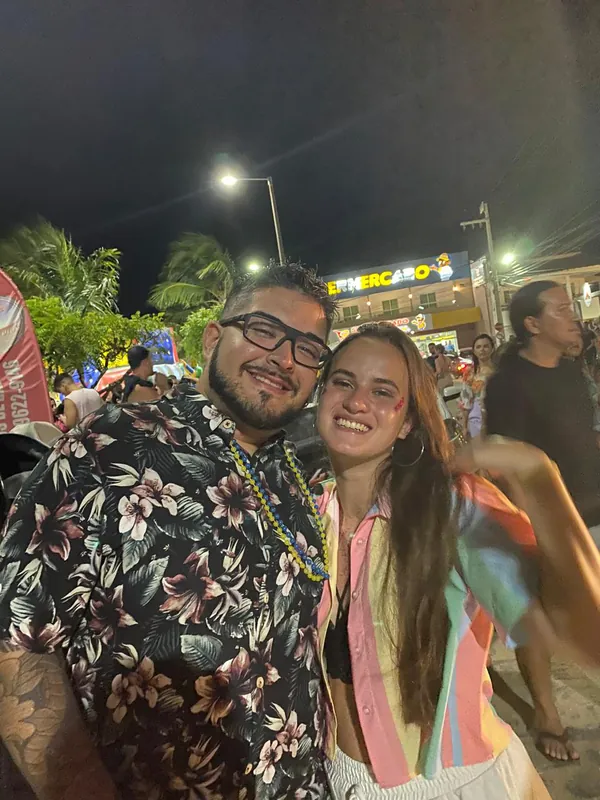 Isabel e Heins abraçados no Carnaval de rua de Flecheiras, no Ceará, à noite.